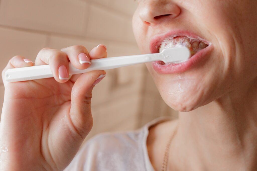 woman brushing teeth in bathroom close up 2026 01 05 06 00 14 utc